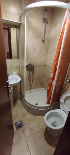 uma casa de banho com um chuveiro, um WC e um lavatório. em Restoran Filipovic em Nova Varos