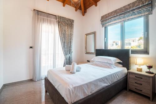 een slaapkamer met een groot bed en een groot raam bij Villa Nikolaos 2 in Fánai