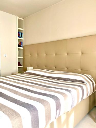 une chambre avec un grand lit avec une grande tête de lit dans l'établissement Chantal Deluxe, à Saint-Tropez