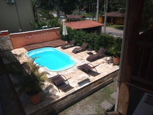an outdoor swimming pool with lounge chairs and a swimming pool at POUSADA PILLAR in Paraty