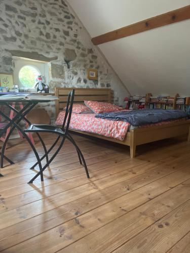 a bedroom with a bed and a table and a stone wall at B&B Au Pain Quotidien in Barizey