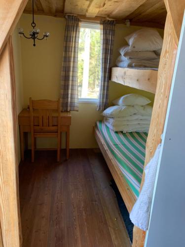 Zimmer mit einem Etagenbett und einem Stuhl in der Unterkunft Sävsjön in Mjöbäck