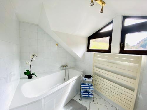 La salle de bains blanche est pourvue d'une baignoire et d'une fenêtre. dans l'établissement Schloss Süßenstein, à Hüttenberg