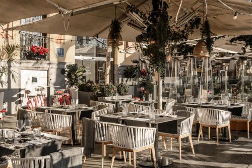 a restaurant with tables and chairs in a building at Hospes Puerta de Alcal&aacute;, a Member of Design Hotels in Madrid