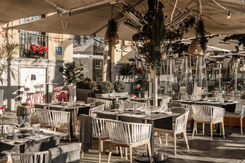een restaurant met tafels en stoelen in een gebouw bij Hospes Puerta de Alcalá, a Member of Design Hotels in Madrid