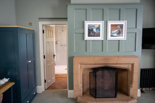 a living room with a fireplace with two pictures on the wall at Victoria Hotel by Chef & Brewer Collection in Menai Bridge
