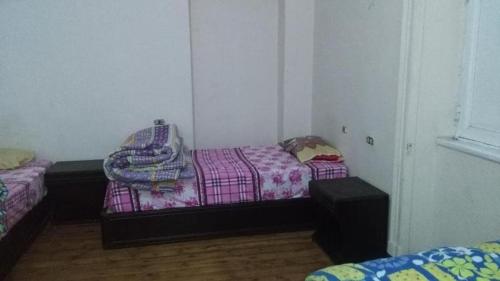 Cette petite chambre comprend 2 lits et une fenêtre. dans l'établissement Grand Safari Hostel, au Caire