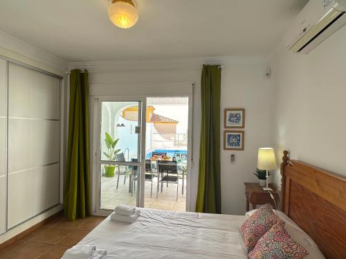 a bedroom with a bed and a view of a patio at Nerja Paradise Rentals - Villa Dos Ardillas in Nerja