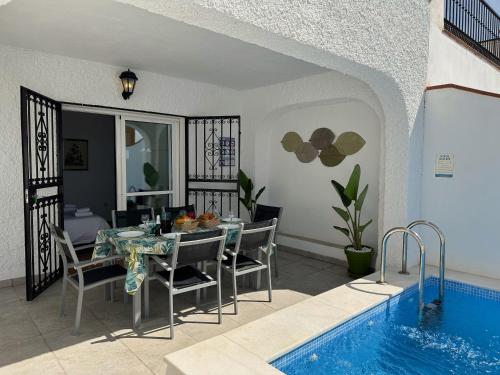 a dining room with a table and a swimming pool at Nerja Paradise Rentals - Villa Dos Ardillas in Nerja
