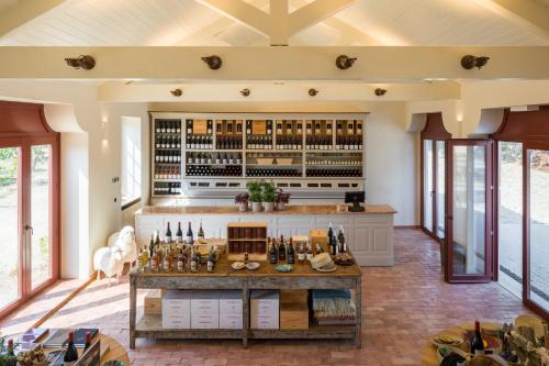 uma cozinha em plano aberto com um bar com garrafas de vinho em Taboadella Casa Villae 1255 - Relais & Châteaux em Sátão