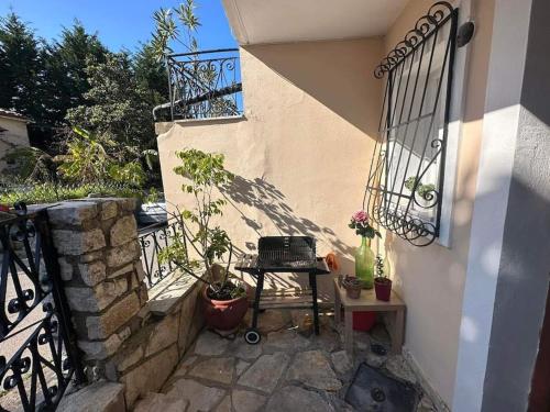a balcony with a table and potted plants next to a building at Mon Repo Apartment Corfu in Corfu Town