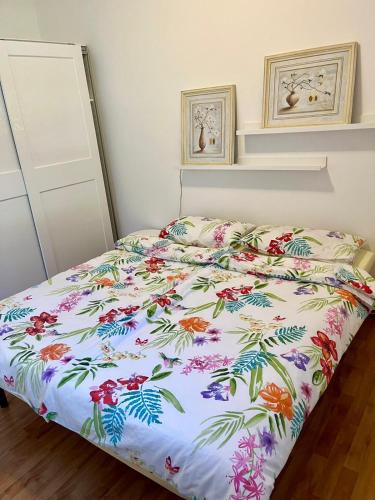 ein Bett mit einer geblümten Bettdecke in einem Schlafzimmer in der Unterkunft Barbara in Ghiffa