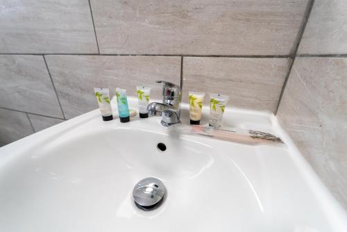 un lavabo blanco con cepillos de dientes. en Modern Studio 10 mins on train to City!, en Birmingham