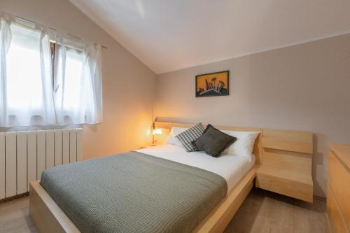 a bedroom with a bed and a window at Apartments Morozin in Krk