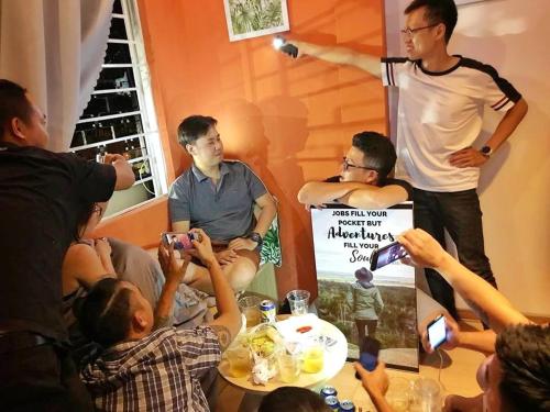 a group of people taking pictures of a man standing in a room at City Hostel Da Nang in Da Nang