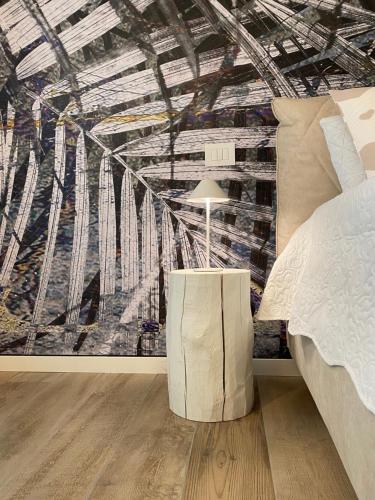 a bedroom with a large painting on the wall at BOUTIQUE HOME LIGNANO in Lignano Sabbiadoro