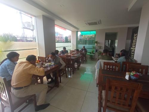 a group of people sitting at tables in a restaurant at Hotel Krishna Kathmandu in Kathmandu