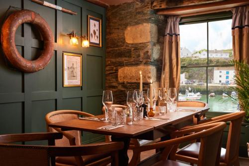 een lange tafel in een restaurant met een raam bij Harbour Inn in Porthleven