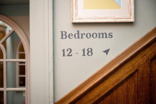 a clock on the wall of a door with the words bathrooms at Victoria Hotel by Chef & Brewer Collection in Menai Bridge