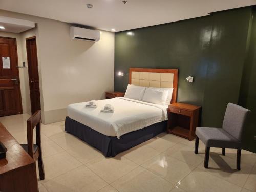 a bedroom with a bed and a chair in it at Hotel Herencia 625 in Daraga