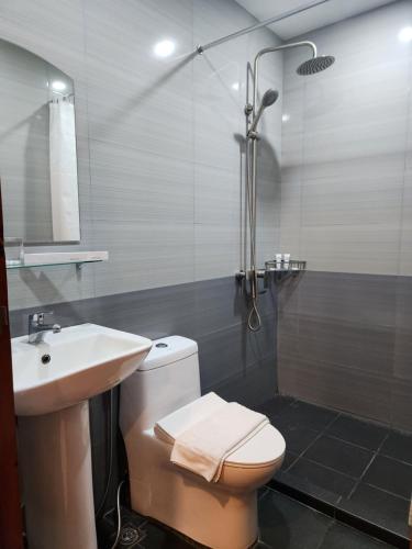 ein Bad mit einem WC, einem Waschbecken und einer Dusche in der Unterkunft HOTEL HERENCIA 625 formerly Abaca Suites in Locsin