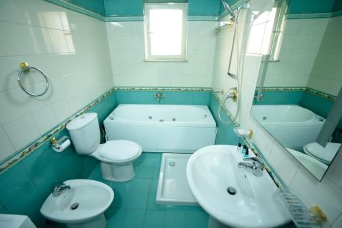 Amli Apartament في تيرانا: حمام مع حوض ومرحاض وحوض استحمام