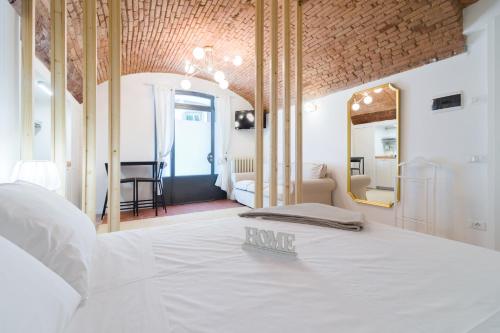 - une chambre avec un lit blanc et un miroir dans l'établissement BERGAMO art - PORTA AGOSTINO, à Bergame