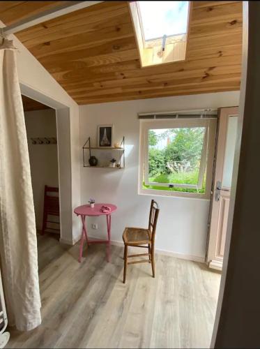 une chambre avec une table rose et une fenêtre dans l'établissement Chambre d hotes, à Mesves-sur-Loire