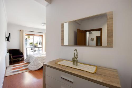 a bathroom with a sink and a mirror on the wall at Corrente do Oudinot perto da praia in Gafanha da Nazaré