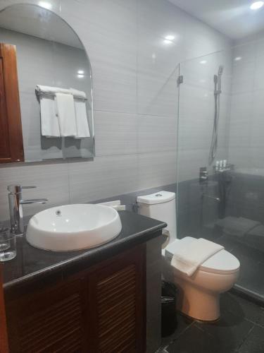 a bathroom with a sink and a toilet and a shower at Hotel Herencia 625 in Daraga