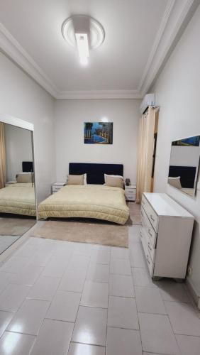 1 dormitorio con cama, tocador y espejo en F2 Appart Les Ambassades Point E, Dakar, en Dakar