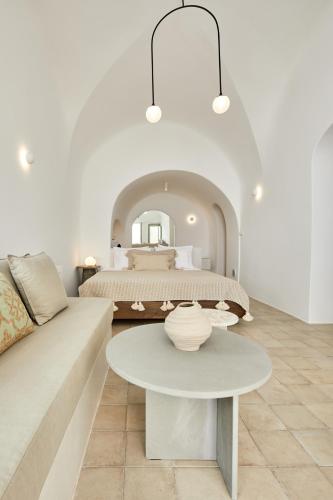 a bedroom with a bed with a table and a couch at Thiro Exclusive Villa with private jacuzzi in Pirgos