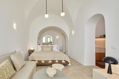 a white bedroom with a bed and a couch at Thiro Exclusive Villa with private jacuzzi in Pirgos