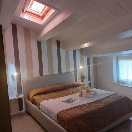 a bedroom with a large bed with striped walls at AURUM Affittacamere in Loreto
