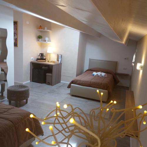 a bedroom with two beds and a desk with lights at AURUM Affittacamere in Loreto