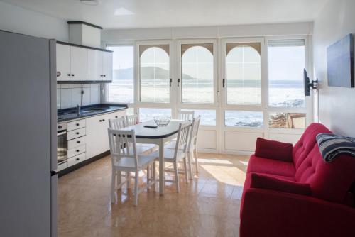 a kitchen and dining room with a table and chairs at Apartamentos pilucha in Muxia