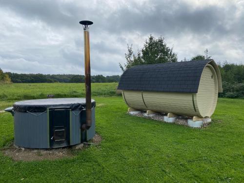 a smallshed with a roof on top of a field at Ferienhaus Norway in Wittenbeck