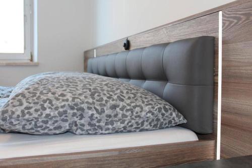 Una cama con una almohada negra y gris. en Zum Breyer BNB City Apartment, en Baden