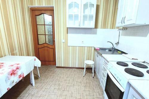 a kitchen with a bed and a sink and a stove at Аэропорт Астана 5 минут юг1 in Astana
