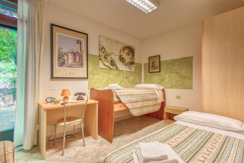 a bedroom with a desk and a bed and a desk and a bed at B&B San Rocco in Capo di Ponte