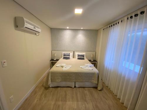 1 dormitorio con 1 cama con 2 toallas en Ipê Amarelo Cama e Café, en Gramado