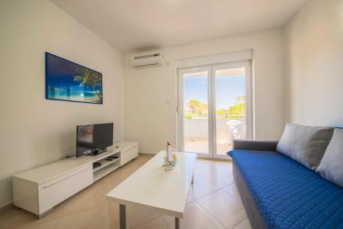 a living room with a blue couch and a tv at Modern Apartment in Vrsi, 45 m², spacious terrace in Vrsi
