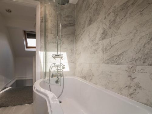 Rose Cottage في ويتبي: حمام مع حوض استحمام مع دش ومرحاض