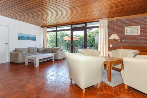 a living room with a couch and a table and chairs at Ferienhaeuser Strandburgen in Bensersiel