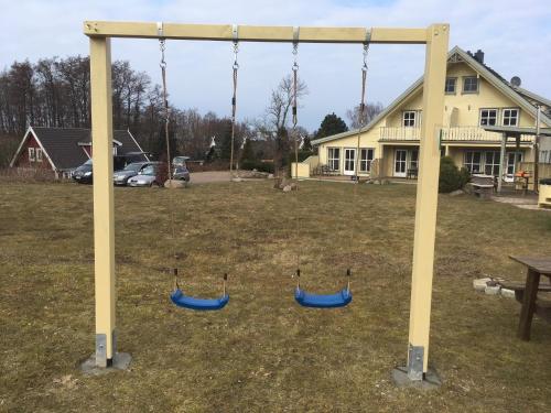 three swings in a yard with a house at Ferienhaus Norway in Wittenbeck