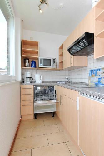 a kitchen with a stove and a sink at Ferienhaeuser Strandburgen in Bensersiel