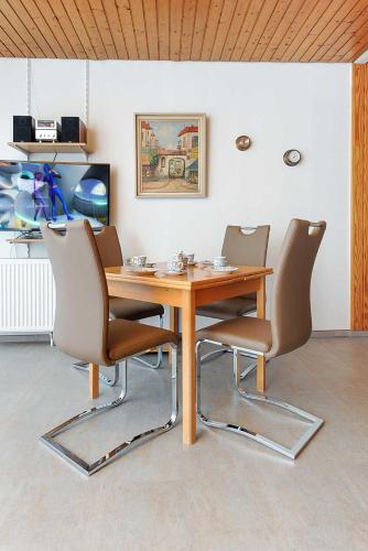 a wooden table and chairs in a room at Ferienhaeuser Strandburgen in Bensersiel