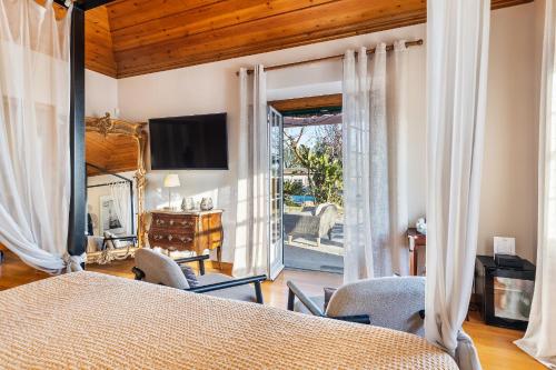 a bedroom with a bed and a sliding glass door at Quinta de Santa Margarida - Charm Country House in Tavira