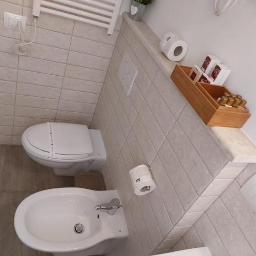 a white bathroom with a toilet and a sink at AURUM Affittacamere in Loreto