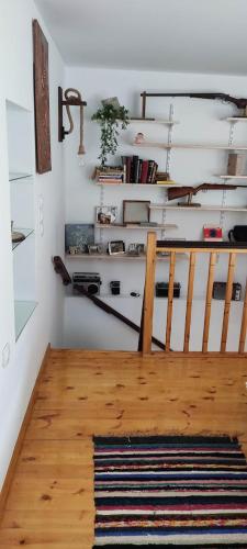 a room with a staircase with white walls and a rug at Charlami's Mansion -Παραδοσιακό Πέτρινο Σπίτι με Τζάκι και Πανοραμική Θέα in Polýdroson